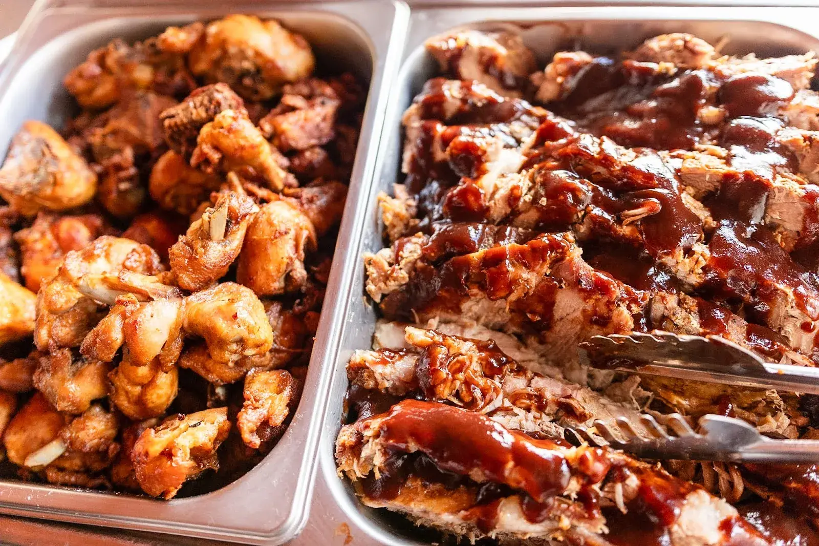 Carnes ao molho barbecue e frango nas cubas do buffet